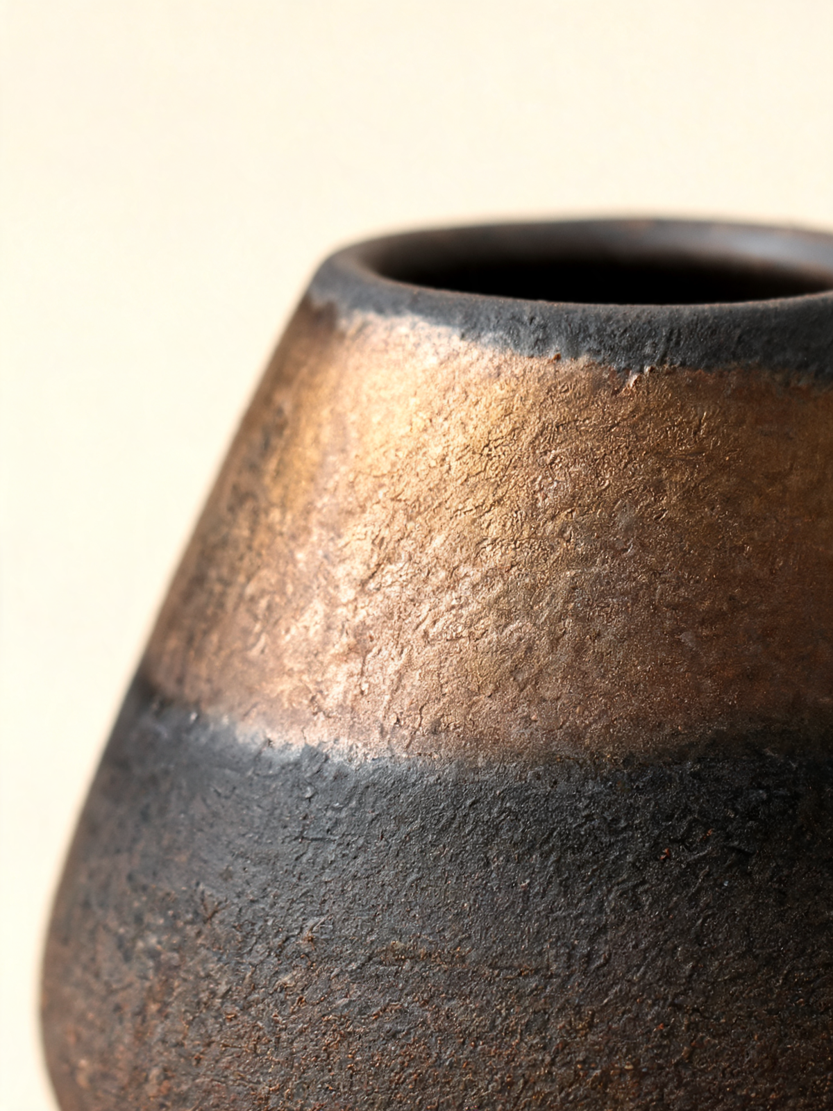 Detail of the golden bronze band across the matte black ceramic